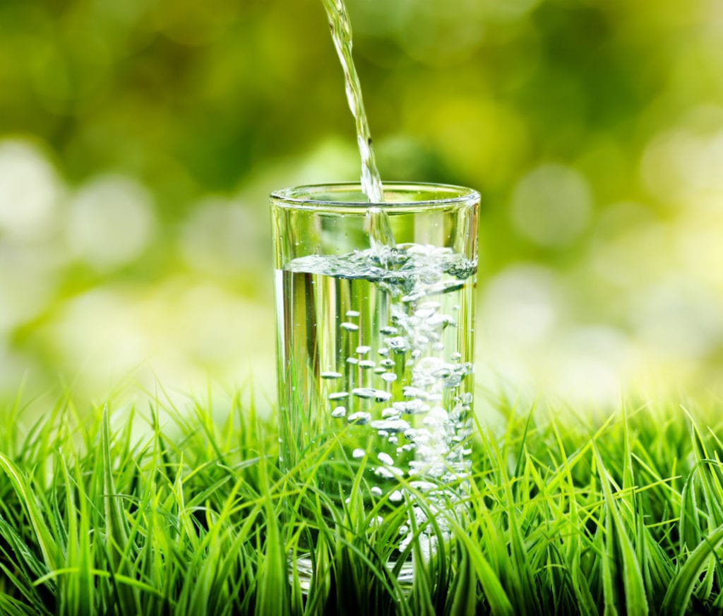 Glass of water on nature background.